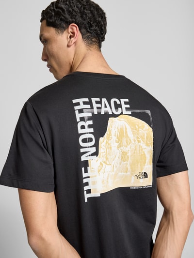 Männermodel trägt T-Shirt mit Logo und Rundhalsausschnitt von The North Face, Baumwoll-Mix, Regular Fit, schwarze Farbe, Ganzkörperansicht Rückansicht.