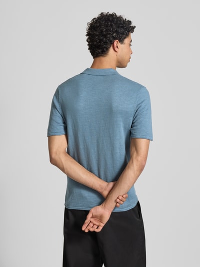Mężczyzna model nosi Slim Fit Koszulka polo w imitacji dzianiny Model 'Kane' od JACK & JONES z bawełny, kołnierzykiem polo, krótki rękaw, długość tyłu w rozmiarze M: 67 cm, kolor niebieski, widok całej sylwetki od tyłu.