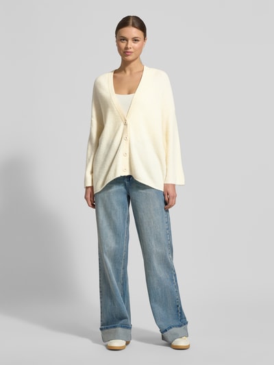 Frauenmodel trägt Relaxed Fit Cardigan mit Woll-Anteil Modell 'Damsville' von American Vintage in Creme, Strick-Optik, Ganzkörperansicht von vorne