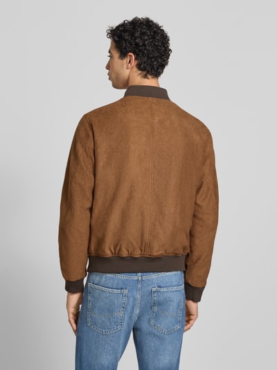 Męski model nosi bomberkę in Leder-Optik mit Stehkragen von Jack & Jones, brąz, krój regular fit, wpuszczane kieszenie, zamek błyskawiczny, długość tyłu w rozmiarze M: 64 cm, szerokość ramion w rozmiarze M: 45 cm, szerokość klatki piersiowej w rozmiarze M: 52 cm, długość rękawów w rozmiarze M: 67 cm, widok całej sylwetki z tyłu