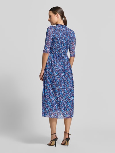 Männermodel trägt sukienka midi 'Midikleid mit Smok-Detail' von Rich & Royal aus elastyczna mieszanka materiałów, taliowany krój, marszczony detal, stójka z obszyciem falbanami, rękaw o dł. 1/2, kwiatowy nadruk na całej powierzchni, Długość tyłu w rozmiarze S: 120 cm, Szerokość w rozmiarze S: 34 cm, Długość rękawów w rozmiarze S: 36 cm, przewaga niebieskich i różowych odcieni, tekstura delikatna, Ganzkörperansicht Rückansicht.