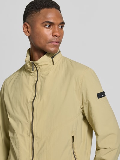 Männermodel trägt Regular Fit Jacke mit Stehkragen von bugatti in Beige, Zweiwege-Reißverschluss, Nahaufnahme Oberkörper.