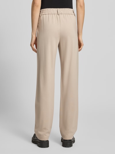 Frauenmodel trägt Straight Fit Hose aus Viskose-Mix Modell 'POPTRASH' von Only in Beige mit elastischem Bund und Seitentaschen, Ganzkörperansicht Rückansicht.