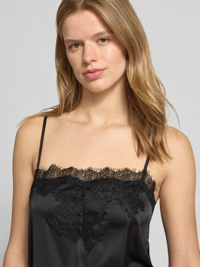 Vrouwenmodel draagt Spitzentop met verstellbare spaghettibandjes van Gina Tricot in zwart materiaalmix met stretch, kant, straight fit, ruglengte bij maat S 45 cm, nahaufnahme bovenlichaam.