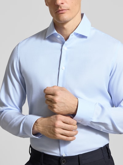Mannenmodel draagt Slim Fit Business-Hemd aus Baumwolle mit Kentkragen van SEIDENSTICKER in lichtblauw, fijn gestructureerd, knoopsluiting, pure katoen, slim fit, borst en schouders zichtbaar, vooraanzicht bovenlichaam.