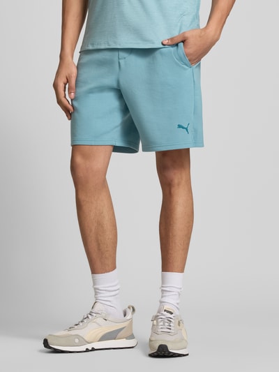 Männermodel trägt Straight Fit Shorts mit Lyocell-Anteil Modell 'Cloudspun' von PUMA PERFORMANCE in Hellblau, elastischer Bund, Gesäßtasche, Logo-Detail, Ganzkörperansicht von vorne.