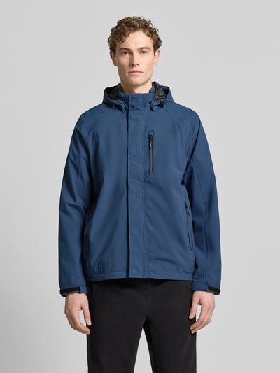 Männermodel trägt blaue Jacke mit Napoleontasche Modell 'KOS' von Killtec, Kapuze mit Tunnelzug, gerade Passform, Ganzkörperansicht von vorne