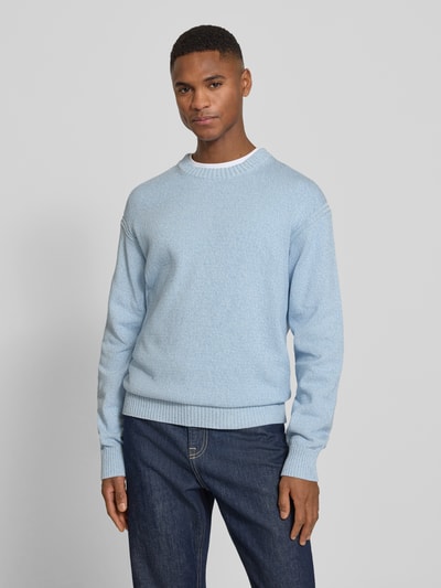 Männermodel trägt Regular Fit Pullover aus reiner Baumwolle Modell 'KERLINO' von BOSS Orange in hellblauer Melange-Strickoptik, gerippte Abschlüsse, Label Patch, Ganzkörperansicht von vorne.