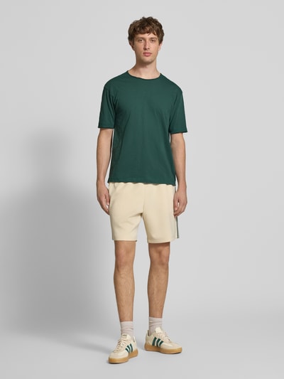 Männermodel trägt Relaxed Fit T-Shirt aus reiner Baumwolle von Marc O'Polo Denim, Optik: Unifarben, Raw Cut Saum, Ganzkörperansicht von vorne.