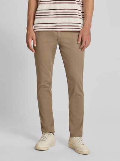Męski model nosi Slim Fit spodnie z kieszeniami z tyłu Model 'MARCO' od Jack & Jones, mieszanka bawełny i elastanu, krój slim fit, szerokość w rozmiarze 32/32: 43 cm, długość wewnętrzna nogawki w rozmiarze 32/32: 77 cm, jasnobrązowy kolor, gładka faktura, widok z przodu na całą sylwetkę.