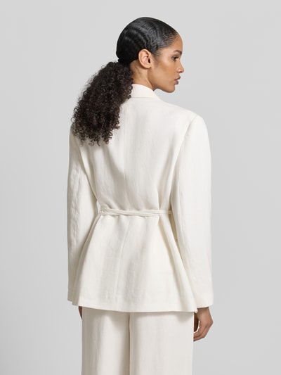Frauenmodel trägt Anzugblazer mit Reverskragen von Jake*s Collection in Creme, taillierte Passform mit Stoffband, Paspeltaschen, Rückenlänge 65 cm, Brustweite 60 cm, Ärmellänge 42 cm, Ganzkörperansicht Rückansicht.