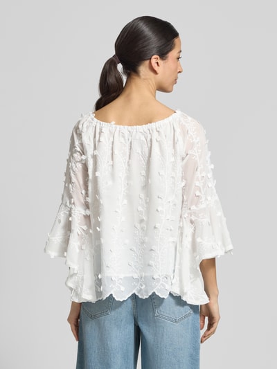 Männermodel trägt Blusenshirt mit Spitze von Apricot, luźny krój, dekolt carmen, koronka, falbany, długość pleców 51 cm, rękaw 42 cm, tekstura z wyraźnym wzorem, biała kolorystyka, Ganzkörperansicht Rückansicht.