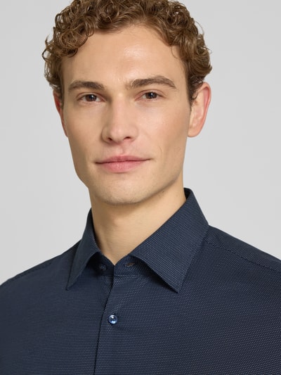 Męski model nosi Regular Fit Businesshemd aus Baumwoll-Mix Modell 'KENT SH C1' od BOSS, krój regular fit, wzór allover, popelina, zbliżenie na górną część ciała.