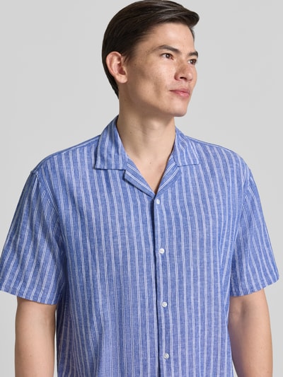 Männermodel trägt Regular Fit Freizeithemd aus Leinen-Baumwoll-Mix von MCNEAL in Blau mit weißen Streifen, Nahaufnahme Oberkörper. Reverskragen, Knopfleiste, Größe M mit 72 cm Rückenlänge, 53 cm Schulterbreite, 26 cm Ärmellänge.