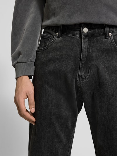 Männermodel trägt Bootcut Fit Jeans aus Baumwoll-Mix von Don't Waste Culture, schwarzer Denim, 5-Pocket-Design, Nahaufnahme Hüfte.
