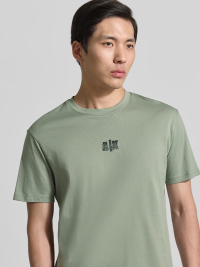 Männermodel trägt T-shirt mit logo en ronde hals van ARMANI EXCHANGE, puur katoen, regular fit, ruglengte maat M 82 cm, Nahaufnahme Oberkörper.