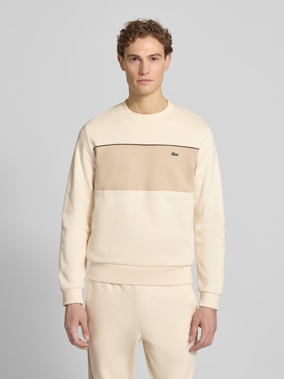Männermodel trägt Regular Fit Sweatshirt aus reiner Baumwolle von Lacoste in Two Tone Optik mit Label Patch, Rundhals, langarm; Ganzkörperansicht von vorne.