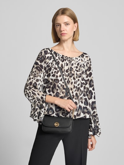 Frauenmodel trägt Shoulder Bag aus echtem Leder Modell 'Nolita' von MICHAEL Michael Kors, schwarz, Kettenriemen, Ganzkörperansicht von vorne.