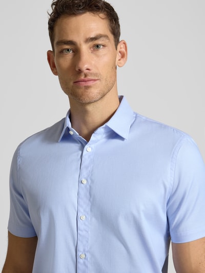 Männermodel trägt Slim Fit Business-Hemd aus Baumwolle mit Kentkragen von Jake*s in Hellblau, glatte Textur, Nahaufnahme Oberkörper. Rückenlänge 78 cm, Schulterbreite 47 cm, Ärmellänge 24 cm, Knopfleiste, reine Baumwolle.