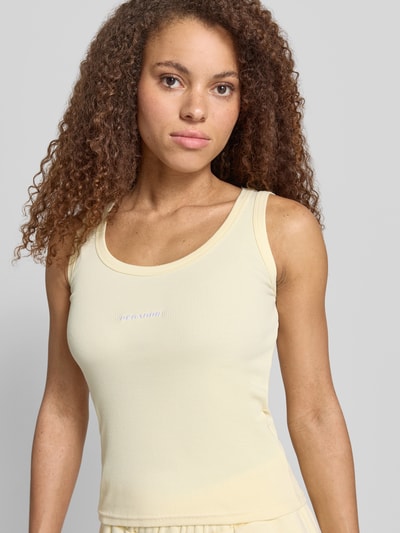 Frauenmodel trägt Tanktop mit Logo-Stitching Modell 'CESIS' von Pegador aus Baumwoll-Mix mit Stretch-Anteil, Körpernaher-Schnitt, Feinripp, Rundhalsausschnitt, Rückenlänge 52 cm in Größe S, Nahaufnahme Oberkörper.