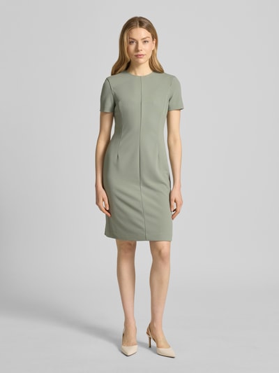 Modelka kobieca nosi Knielanges Etuikleid mit Rundhalsausschnitt von Calvin Klein Womenswear, materiał z domieszką stretchu, prosty krój, długość do kolan, okrągły dekolt, długość pleców w rozmiarze S: 92 cm, szerokość w rozmiarze S: 43 cm, długość rękawa w rozmiarze S: 19 cm, kolor jasnosalwiowy, gładka tekstura, widok całej sylwetki z przodu.