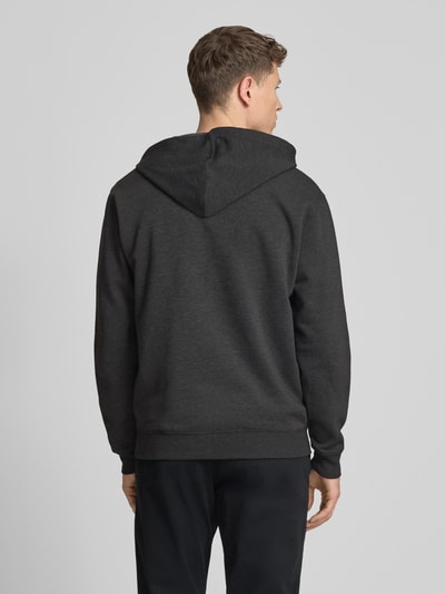 Männermodel trägt Sweatjacke mit Logo und Känguru-Tasche von GAP, dunkelgrau, Baumwoll-Mix, Regular-Fit, Kapuze, Ganzkörperansicht Rückansicht.