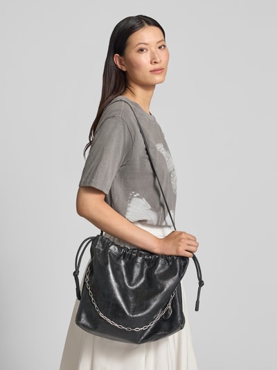 Frauenmodel trägt Pouch mit Raffungen Modell 'Lya' von LIEBESKIND BERLIN, schwarzes Leder, Hauptfach mit Tunnelzug, schmaler Schulterriemen, Ganzkörperansicht von vorne. Breite 41 cm, Länge 30 cm, Tiefe 11 cm, Riemenlänge 98 cm.