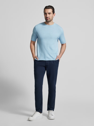 Männermodel trägt Strickshirt mit Kaschmir-Anteil und Knopfleiste von FTC Cashmere, hellblau, Slim Fit, Baumwoll-Mix, Ganzkörperansicht von vorne.