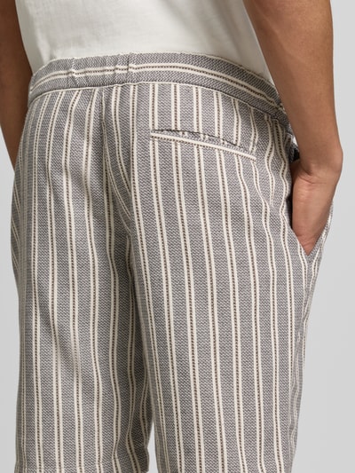 Männermodel trägt Bermudas mit Gesäßleistentasche und Kordelzug von MCNEAL im Baumwoll-Mix mit Streifenmuster, Detailaufnahme Rückansicht. Kontexthinweis: Herren Bermudas, Straight Fit, elastischer Bund mit Kordelzug, französische Eingrifftaschen, Bundweite 46 cm, Innenbeinlänge 25 cm.