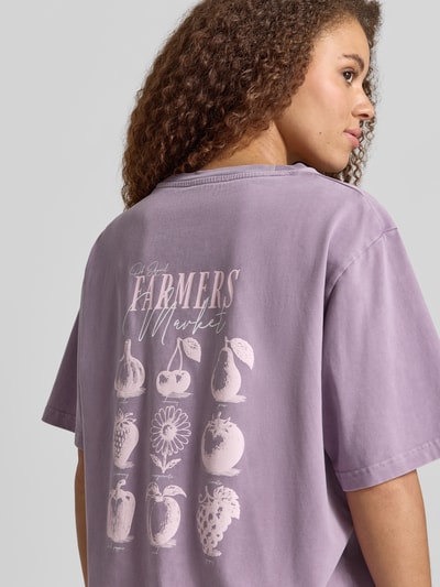 Frauenmodel trägt Oversized Damen T-Shirt aus Reine Baumwolle von OH APRIL, Modell 'Farmers Market' mit Label-Stitching, Rückenlänge 72 cm, Ganzkörperansicht Rückansicht.