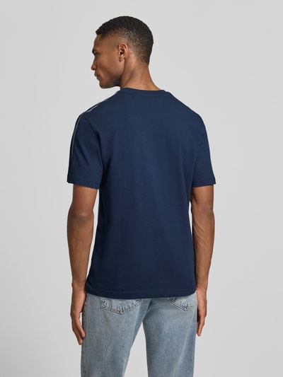Męski model nosi Regular Fit T-Shirt aus reiner Baumwolle von Lacoste, granatowy, jednolity, label-tape, okrągły dekolt, krótki rękaw, czysta bawełna, Ganzkörperansicht Rückansicht.