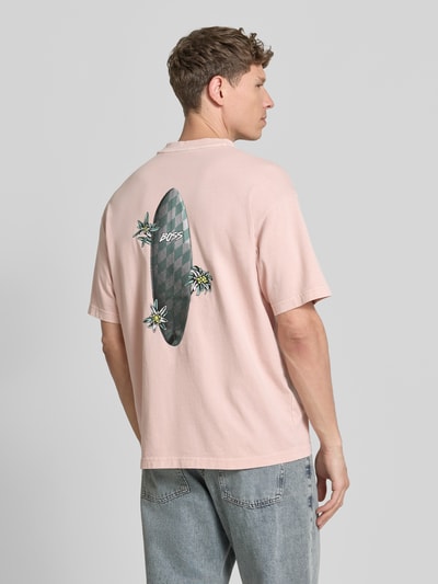 Männermodel trägt Regular Fit T-Shirt aus reiner Baumwolle Modell 'SURFWASH' von BOSS Orange, Optik: Unifarben, Label-Print, Rückansicht.