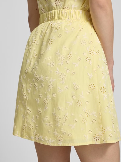 Frauenmodel trägt Regular Fit Mini-Rock aus reiner Baumwolle Modell 'BANNA' von Pieces, gelb, floral, Popeline, Detailaufnahme Rückansicht.