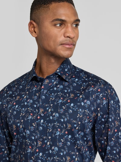 Männermodel trägt Regular Fit Businesshemd aus reiner Baumwolle mit Kentkragen von OLYMP, florales Muster, Nahaufnahme Oberkörper.