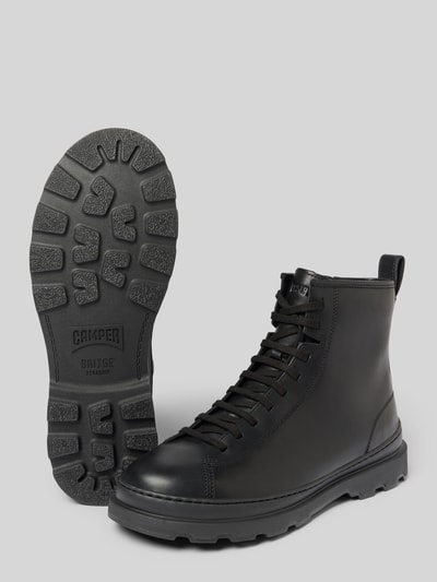 Produktfoto, Stiefel aus echtem Leder Modell 'Brutus' von Camper in Schwarz mit Schnürverschluss, profilierter Sohle und 3 cm Absatz, abgerundete Passform, neutrale graue Hintergrundfläche