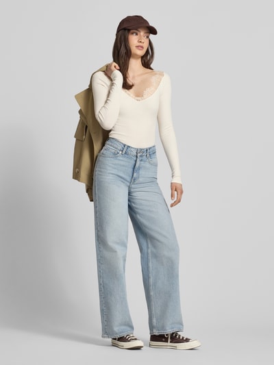 Frauenmodel trägt Longsleeve mit V-Ausschnitt und Spitze von Gina Tricot aus Baumwoll-Mix mit Modal-Anteil, Slim-Fit, Feinripp, Rückenlänge bei Größe S: 53 cm, Ganzkörperansicht von vorne.