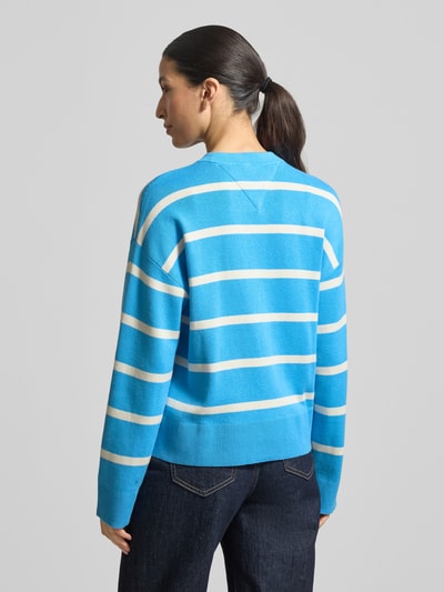 Frauenmodel trägt Regular Fit Sweatshirt aus reiner Baumwolle von Tommy Hilfiger in Blau mit weißen Streifen und Feinstrickstruktur, Ganzkörperansicht Rückansicht.