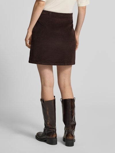 Männermodel trägt Regular Fit Mini-Rock aus Baumwoll-Mix Modell 'ETTA' von VERO MODA, dunkelbraun, glatte Struktur, Ganzkörperansicht Rückansicht. Spódnica mini, Damen Mini-Rock von VERO MODA
