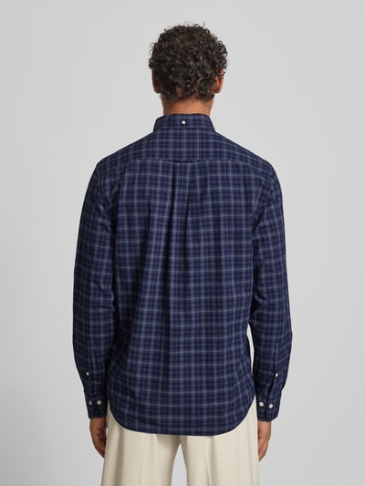 Męski model nosi Koszulę casualową z listwą guzikową od Gant, bawełna, krój regular fit, kołnierzyk typu button down, granatowa krata, kieszeń na piersi, wyhaftowane logo, długość tyłu 76 cm, szerokość ramion 56 cm, długość rękawa 65 cm, widok całej sylwetki z tyłu.