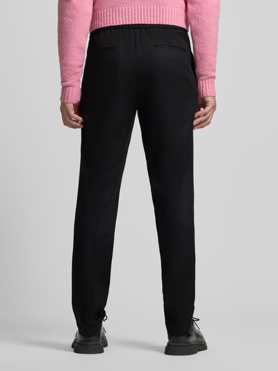 Männermodel trägt Slim Fit Stoffhose aus Lyocell-Mix Modell 'GETLIN251F3' von HUGO, unifarbene Twill-Optik, Ganzkörperansicht Rückansicht.