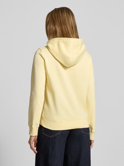 Frauenmodel trägt Regular Fit Hoodie mit Label-Print von Gant aus Baumwoll-Mix in Pastellgelb, Ganzkörperansicht Rückansicht.