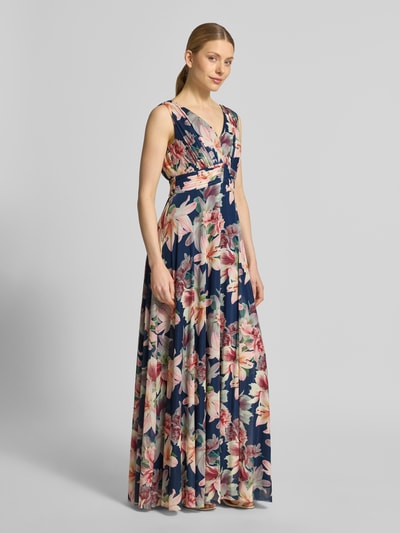 Frauenmodel trägt Maxikleid mit V-Ausschnitt und Gehschlitz von Christian Berg Cocktail, floraler Allover-Look im Material-Mix mit Stretch-Anteil, A-Linie, Ganzkörperansicht von vorne. Rückenlänge bei Größe 36: 150 cm, Brustweite bei Größe 36: 40 cm.