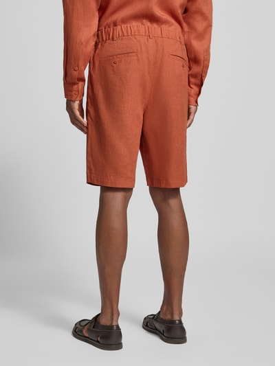 Männermodel trägt Bermudas aus reinem linnen van JAKE*S STUDIO MEN in oranje, losse pasvorm, riemlussen, steek- en achterzakken, knoop- en ritssluiting, stolpplooien, deels elastische band, bandwijdte bij maat M 45 cm, binnenbeenlengte 24 cm, ganzkörperansicht rückansicht.