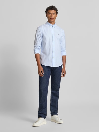 Męski model nosi Slim Fit Freizeithemd aus reiner Baumwolle od Tommy Hilfiger, efekt: wzór na całej powierzchni, popelina, krój slim fit, kołnierzyk typu button down, listwa guzikowa na całej długości, długi rękaw, mankiet na jeden guzik, zaokrąglone wykończenie, czysta bawełna, widok całej sylwetki z przodu.