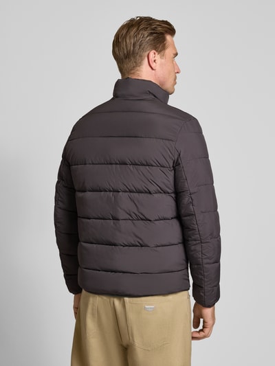 Männermodel trägt Regular Fit Steppjacke mit Stehkragen von Tom Tailor Denim in Dunkelgrau, gesteppt, glatte Struktur, Ganzkörperansicht Rückansicht. Herren Daunenjacke von Tom Tailor Denim.