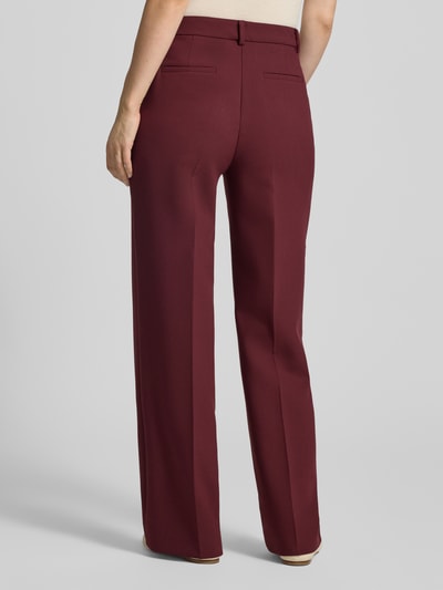 Vrouwenmodel draagt Hose mit Bügelfalten und Eingrifftaschen van MORE, bordeauxrood, met viscose, regular fit, steekzakken, persplooien, bandwijdte maat 36: 41 cm, binnenbeenlengte maat 36: 80 cm, Ganzkörperaanzicht achteraan.