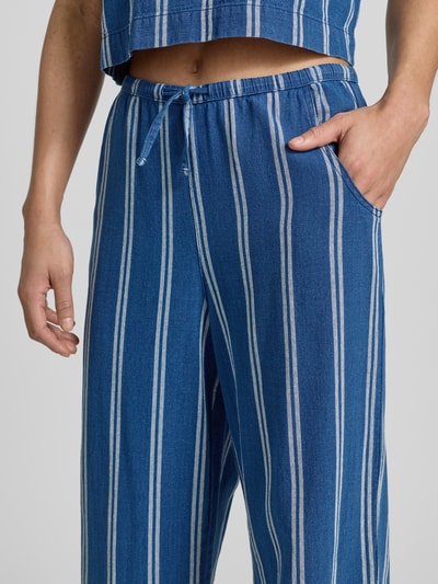 Frauenmodel trägt Wide-Leg-Pants mit elastischem Bund und Kordelzug von Jake*s Casual aus reiner Baumwolle mit französischen Eingrifftaschen, vertikale blaue und weiße Streifen, Nahaufnahme Oberkörper.