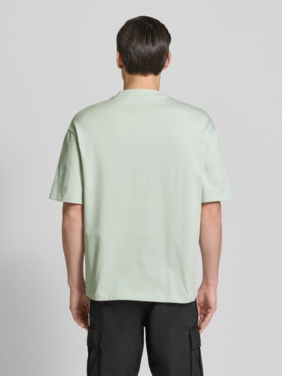 Männermodel trägt Relaxed Fit T-Shirt aus reiner Baumwolle Modell 'DINKEE' von HUGO, Optik: Unifarben, Ganzkörperansicht Rückansicht.