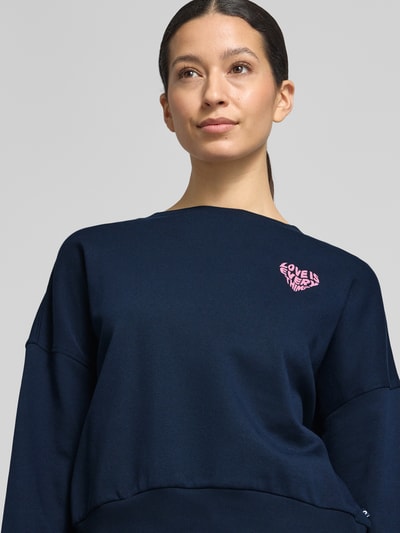 Frauenmodel trägt Regular Fit Sweatshirt aus reiner Baumwolle von Tom Tailor Denim in Dunkelblau, unifarben, Rundhals, Nahaufnahme Oberkörper.