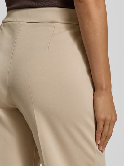Frauenmodel trägt Hose mit Bügelfalten Modell 'PALACE' von EMME, Viskose-Mix, Stretch, Beige, glatte Struktur, Ganzkörperansicht Rückansicht.